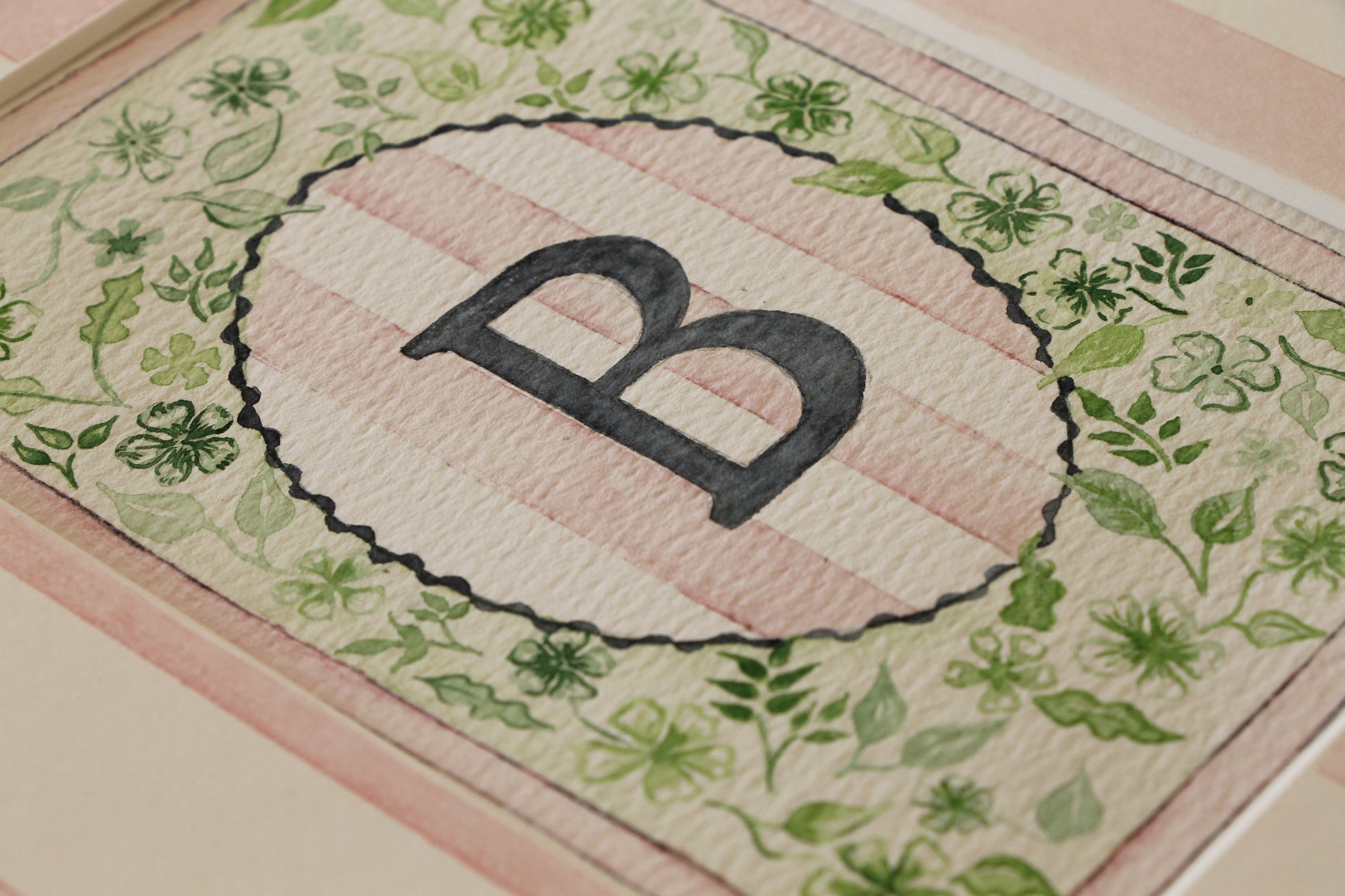 Card with a decorative border and letter 'b' on a floral background